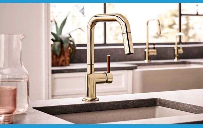 Robinet de cuisine doré haut de gamme installé sur un plan de travail moderne avec un évier en pierre.